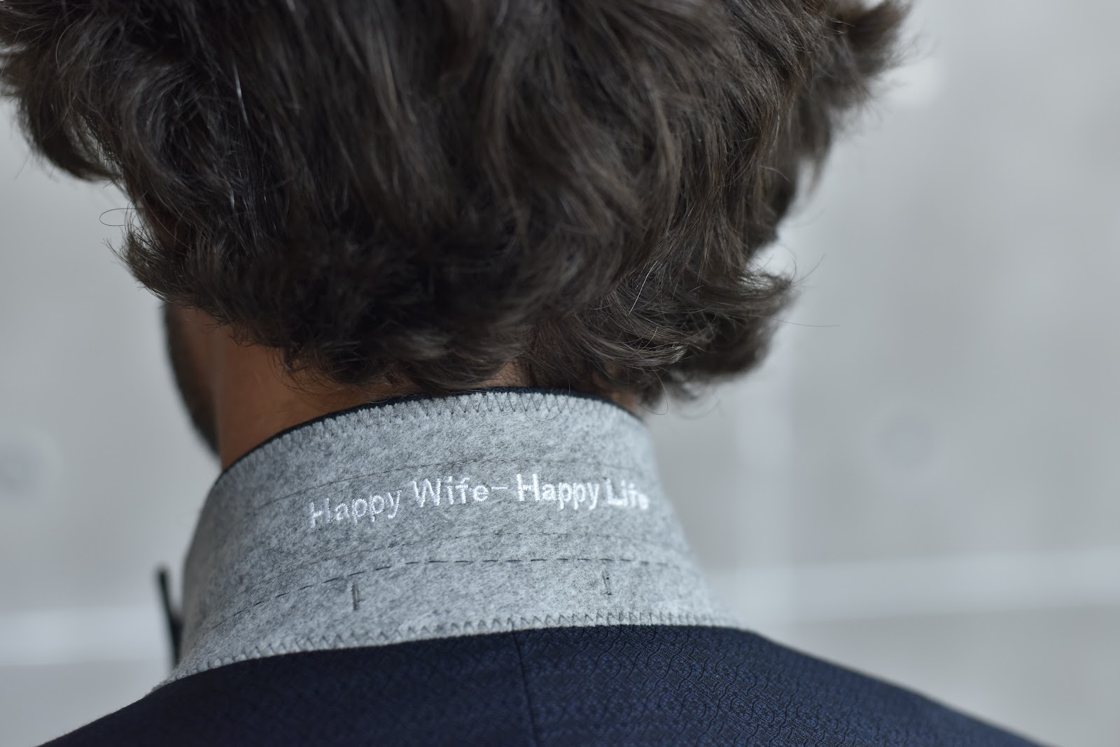 Close up view of a custom navy suit showing intricate lapel stitching and collar construction details